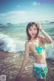 A woman in a bikini standing on the beach.