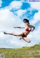 A woman in a red bikini jumping in the air.