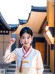 A woman in a white and red hanbok posing for a picture.