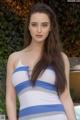 A woman in a blue and white striped dress posing by a pool.