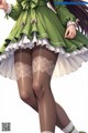 A woman in a green dress and white stockings.